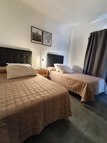 two beds in a hotel room with two beds at Bismark Studio in Marcos Juárez