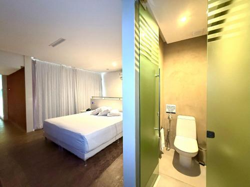 a bedroom with a bed and a bathroom with a toilet at Sensacional Suíte no Union no Jacaré! in Ilha da Restinga