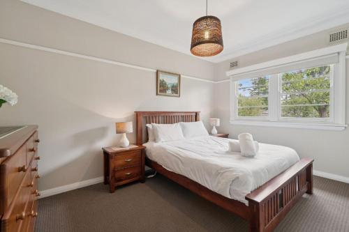 a bedroom with a bed and a window at Balgownie Cottage in Blackheath