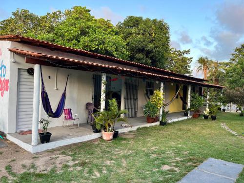 a house with a porch with plants in the yard at Brito Hospedagem in Barreirinhas