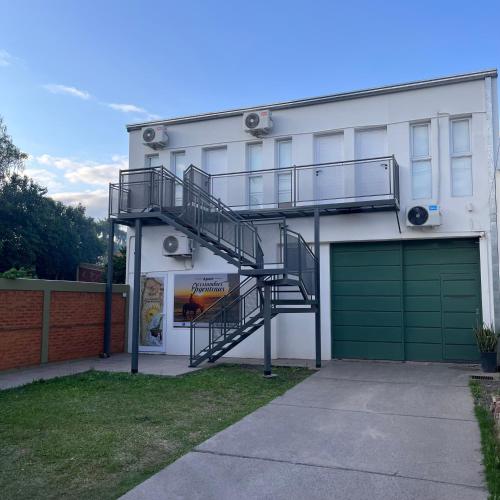 a house with a spiral staircase next to a garage at Apart Costumbres Argentinas in Avellaneda