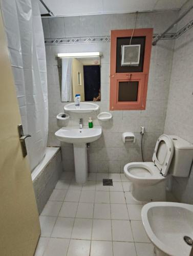 a bathroom with a sink and a toilet and a mirror at Room with Private Bathroom in Abu Dhabi