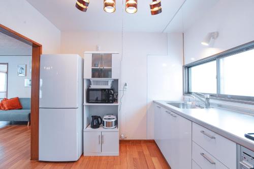 富良野市にあるSouth Furano Houseの白いキッチン(冷蔵庫、シンク付)