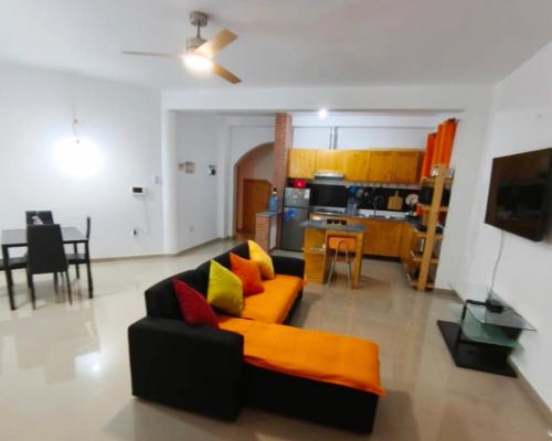 a living room with a couch and a kitchen at Casa Colibri - Confort et Authentique, à 300m de la plage ! in Mindelo