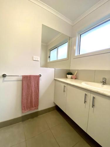 a bathroom with a sink and a mirror at Bella's Beach House in Venus Bay