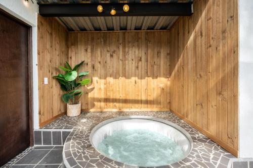 a hot tub in a room with a wooden wall at Aurora Ecoliving Finca a 30 minutos de Medellín in Girardota