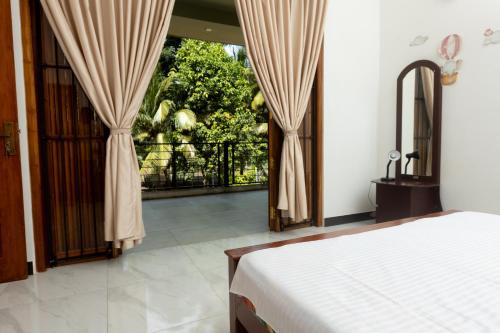 a bedroom with a bed and a sliding glass door at Ivy Garden Retreat in Gampola