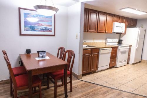 a kitchen with a dining room table and a kitchen with white appliances at Homestead Lodge Apart Hotel in Pleasantville