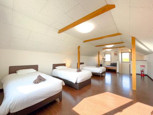 上富良野町にあるNorth Furano Houseのベッド2台とリビングルームが備わる客室です。