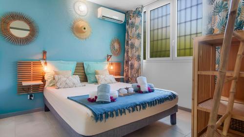 a bedroom with a bed with two babies on it at Escale Marine à deux pas des plages et de la Marina in Les Trois-Îlets