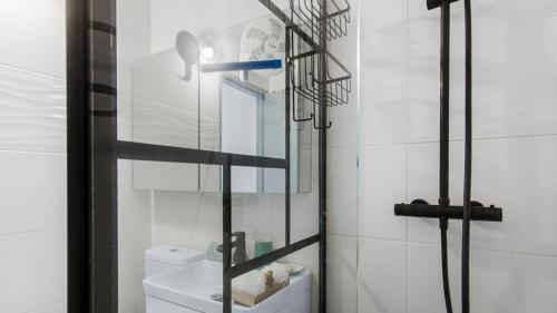a bathroom with a toilet and a glass shower door at Escale Marine à deux pas des plages et de la Marina in Les Trois-Îlets