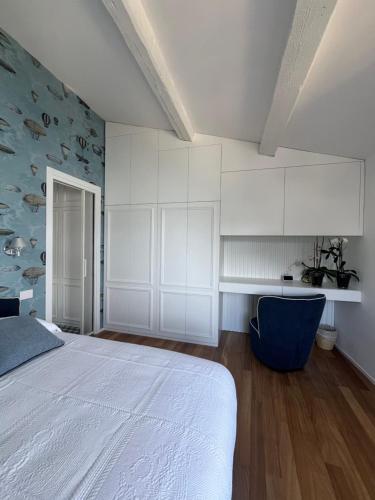 ポルトヴェーネレにあるAbout Italy Holiday Rooms and Apartmentsの白いベッドと青い椅子のある寝室