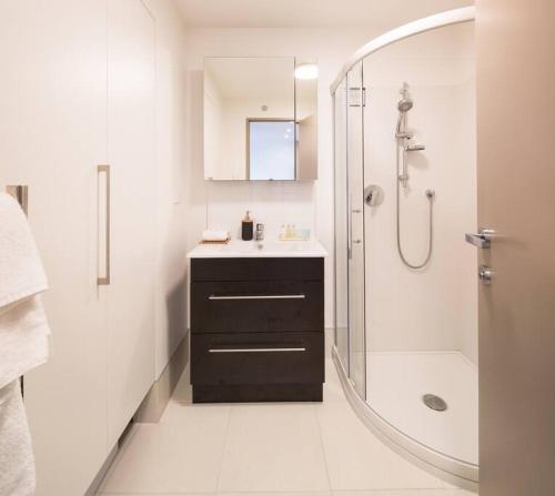 a white bathroom with a sink and a shower at Hello QT Lakeside Gem in Queenstown