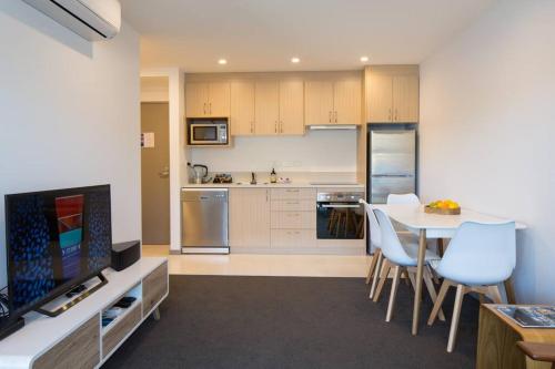 a kitchen with a table and a dining room at Hello QT Lakeside Gem in Queenstown