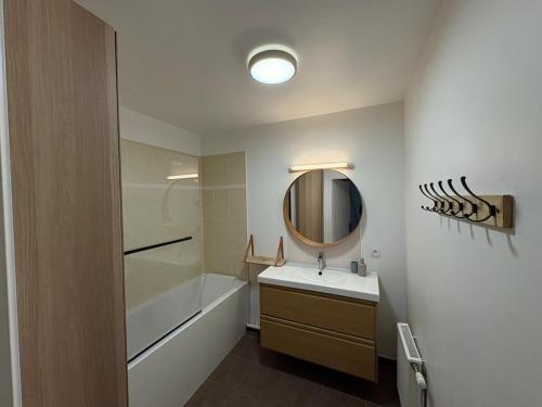 een badkamer met een wastafel en een spiegel bij Chill' Appart Disneyland in Chessy