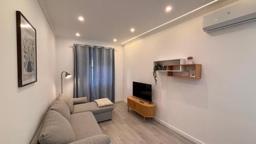 a living room with a couch and a tv at Charming Baixa VII - 1 Room APT in Lavradio