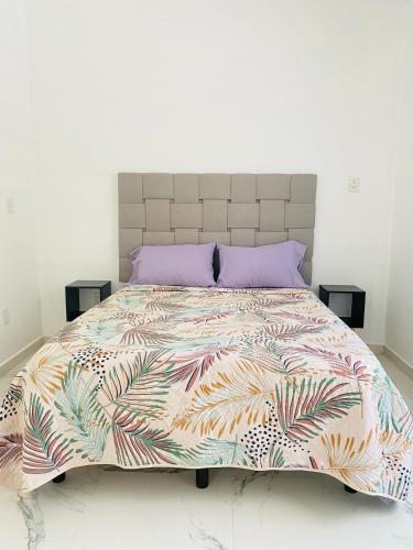 ein Schlafzimmer mit einem großen Bett und einer farbenfrohen Bettdecke in der Unterkunft JiuteHaus 7 in Jiutepec