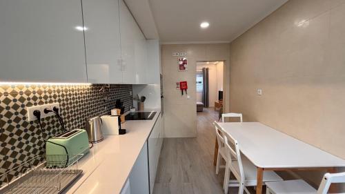 a kitchen with a counter and a table and chairs at Charming Baixa VII - 1 Room APT in Lavradio