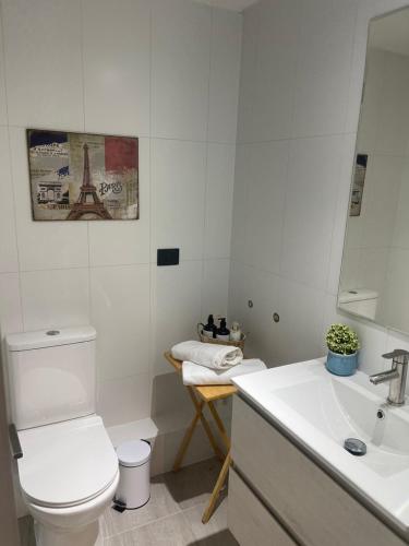 a white bathroom with a toilet and a sink at Puerto Montt Centro - Diagonal Germania con estacionamiento in Puerto Montt