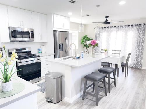 a white kitchen with a large island with a counter top at Newly Remodeled Pool Villa 3BD 3BA By Summerlin in Las Vegas