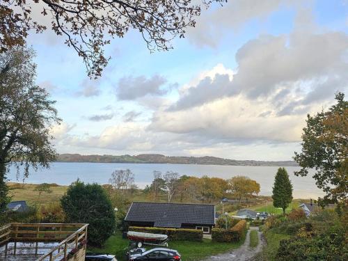 ein Haus mit Solarmodulen neben einem See in der Unterkunft Family-Friendly Cottage Near the Coast in Tirsbæk