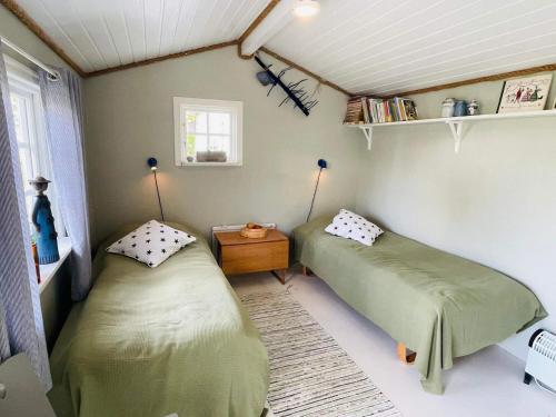 a room with two beds and a table and a window at 2 person holiday home in RAMDALA in Trummenas