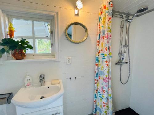 a bathroom with a sink and a shower curtain at 2 person holiday home in RAMDALA in Trummenas