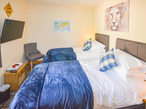 a bedroom with a bed with blue sheets on it at Uplands in Dalbeattie