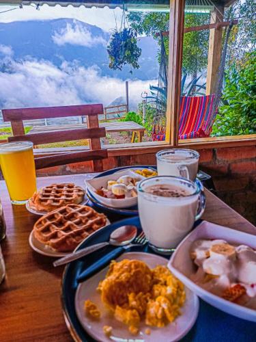a table topped with plates of breakfast food and drinks at Sigchos Lodge in Sigchos