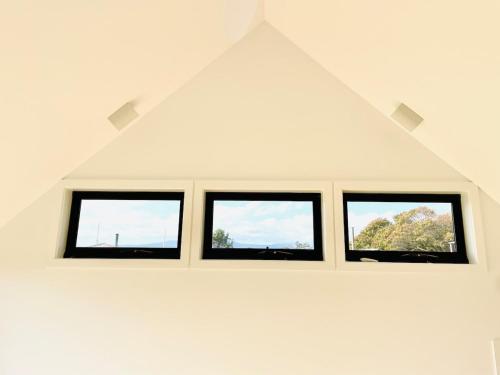 a row of windows in a white room at NEW Luxury Cabin with Scenic Views & Farm Charm in Huonville