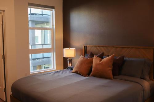 a bedroom with a bed with pillows and a window at Resort-Style APT with Pool, Gym & Parking 10min to Disneyland in Tustin