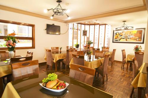 a restaurant with tables and chairs and a bowl of fruit at Centenario Inn in Cusco