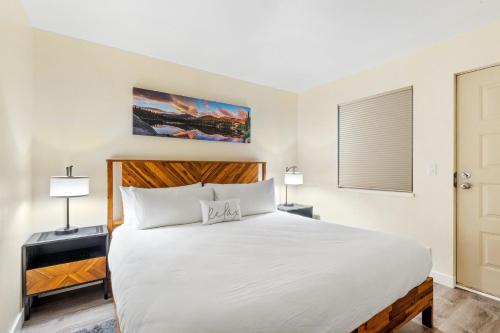a bedroom with a large white bed with two lamps at Fall Line 107 condo in Telluride