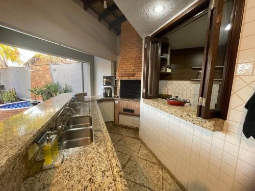 a kitchen with a sink and a counter top at Bela Casa Stella Maris - Casa de Carrara 01 in Andradina