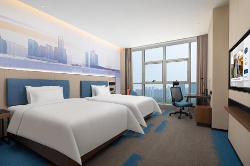 een hotelkamer met twee bedden en een flatscreen-tv bij Hampton by Hilton Hefei Binhu in Hefei