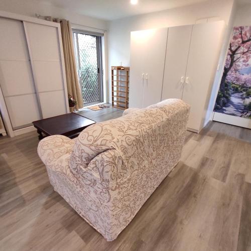 a living room with a couch and a table at Quiet 40m Studio - Kitchen, Washer, AC, Work Desk in Auckland