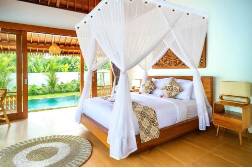 een slaapkamer met een hemelbed en een zwembad bij Ubud Forest Villa with Private Pool and Kitchen in Payangan