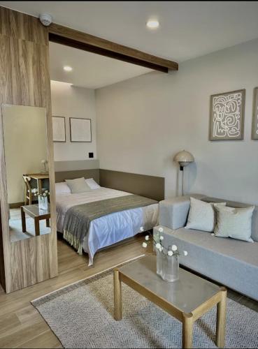 a hotel room with a bed and a couch at Margot Apartments By MrW in Guadalajara