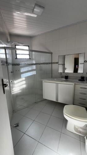 ein weißes Badezimmer mit Toilette und Dusche in der Unterkunft Casa Farol para temporada in Aracaju