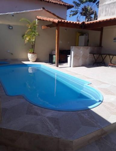 a blue swimming pool in front of a house at relajate en buzios in Búzios