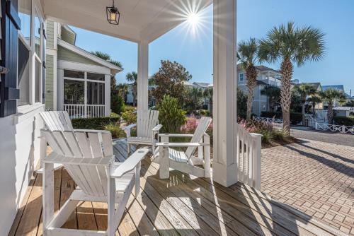 eine Veranda mit weißen Stühlen auf einem Haus in der Unterkunft Blue Dream in Santa Rosa Beach