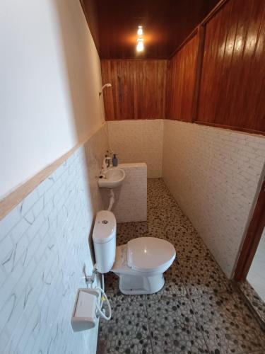 a small bathroom with a toilet and a sink at SeaGarden Guesthouse in Bunaken