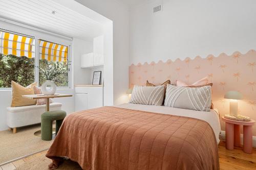 a bedroom with a bed and a chair and a window at Belles Bondi Beach Apartments - 1 and 2 Bedroom Stays - 500m to beach in Sydney