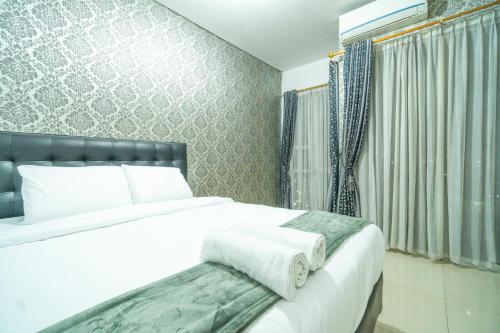 een slaapkamer met een groot wit bed en een raam bij Stylish 1-bedroom in central Jakarta, SCBD in Jakarta