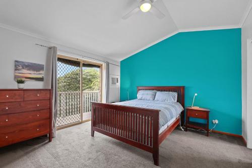a blue bedroom with a bed and a window at 36 Lacrington St, Goolwa Beach in Goolwa South
