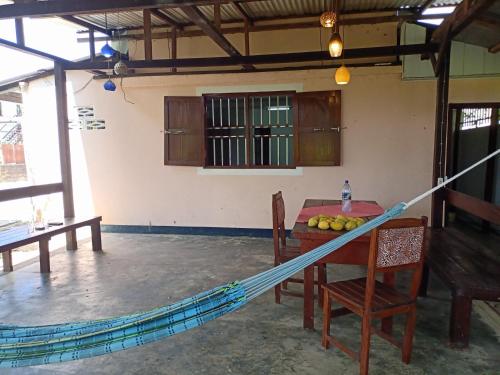 a room with a hammock and a table and chairs at Bovenwoning Masusa in Paramaribo