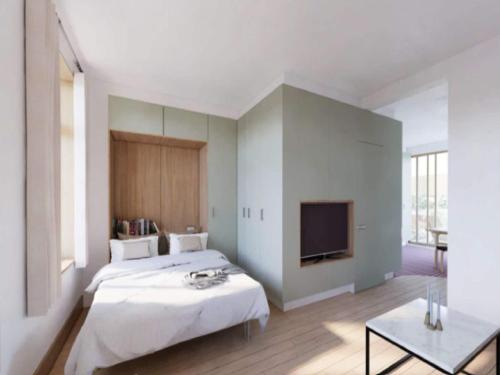 a bedroom with a bed and a flat screen tv at Inviting apartment in Bree with terrace in Bree