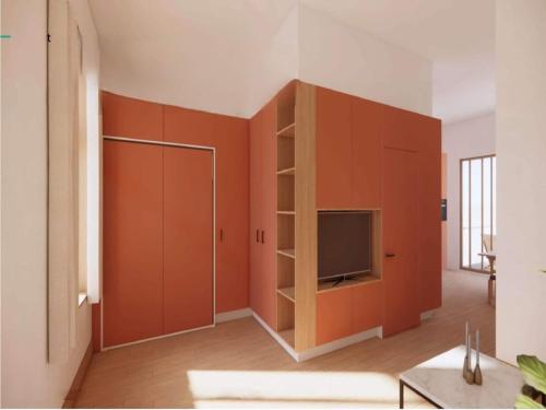 a living room with orange cabinets and a television at Modern apartment in Bree with parking in Mellet