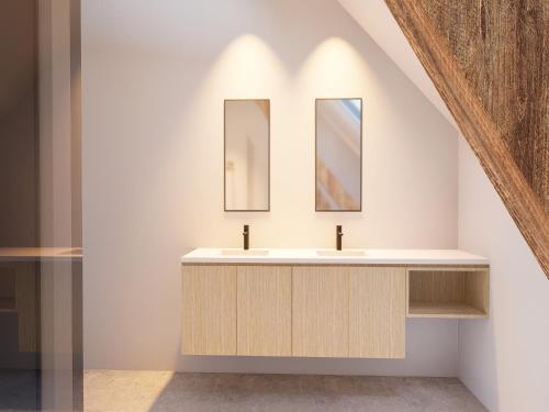 a bathroom with a sink and two mirrors at Spacious 3-Floor Holiday Home for 8 Guests in Bree