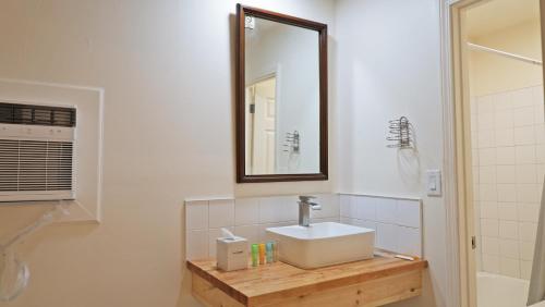 a bathroom with a sink and a mirror at Sawmill Lodges Motel in Hennessey